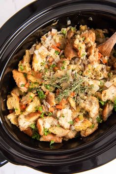 a crock pot filled with stuffing and vegetables