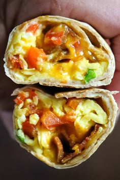 two breakfast burritos are being held in their hand