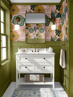 a bathroom with green walls and floral wallpaper on the walls, two sinks and a mirror