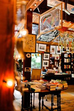 a room filled with lots of books and pictures on the wall next to a table