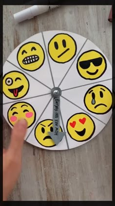 a clock made out of paper with faces drawn on the face and hands pointing at it