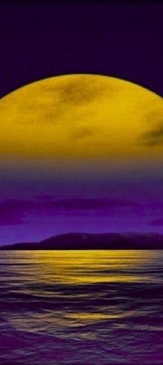 the moon is setting over the ocean with purple and yellow hues in the sky