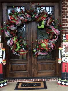 the front door is decorated for christmas with wreaths and nutcrackers on it