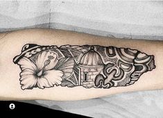 a black and white photo of a tattoo on the arm with flowers in front of it