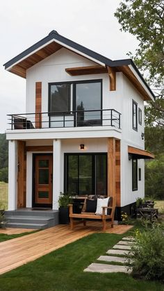 a white house with wood accents and black trims on the front door, windows, and deck