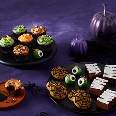 halloween cupcakes and treats on black plates