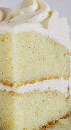 a close up of a slice of cake on a plate with whipped cream frosting