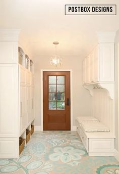 an entryway with white cabinets and blue patterned flooring is seen in this photograph