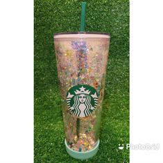 the starbucks cup is covered in glitter and has a straw sticking out of it's lid