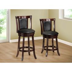 two wooden barstools with black leather upholstered seats in front of a window