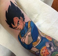 a dragon ball tattoo on the leg of a person with a blue shirt and yellow pants