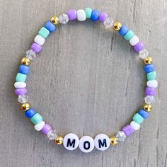 Mom Bracelet 💜🤍 Cute gift for mom! Add more bracelets to create the perfect stack, use kids names or grandkids names. Customize colors and charm ✨✨ Made with 4mm seed beads, bicone beads and gold filled beads ✨ CARING TIPS FOR YOUR JEWELRY ⭐️Treat and store with care. ⭐️ For longevity, avoid exposing your jewelry to water. ⭐️ Avoid having direct contact with lotions, perfumes, sanitizers as these chemicals may cause discoloration of your jewelry. Mom Bracelet Ideas, Casual Heishi Beads Jewelry Gift, Adjustable Stretch Bracelet With 8mm Beads For Birthday, Multicolor Beaded Bracelets For Mother's Day Gift, Friendship Bracelets For Mother's Day With Round Beads, Adjustable 8mm Beads Friendship Bracelets For Birthday, Casual Adjustable Beaded Bracelets For Birthday, Casual Round Beads Jewelry For Birthday, Multicolor Beaded Bracelets For Birthday And Mother's Day