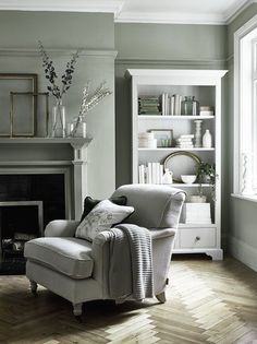 a living room filled with furniture and a fire place in front of a mirror on the wall