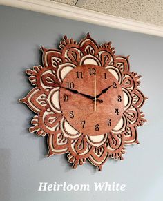 a large wooden clock mounted to the side of a wall in a room with gray walls