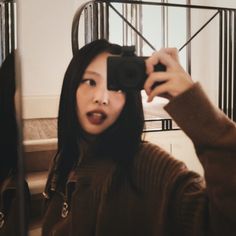 a woman taking a selfie in front of a mirror with a camera on her head