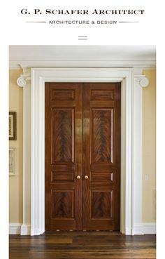 an image of a wooden door in the middle of a room with columns and pillars