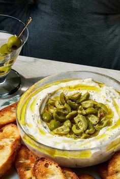 an appetizer with olives and cream cheese in a bowl on a plate