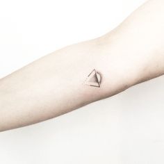 a small triangle tattoo on the arm