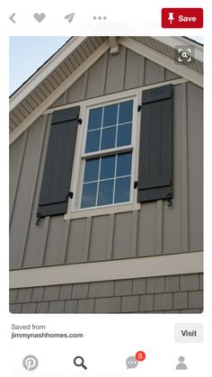 the side of a house with two windows and shutters