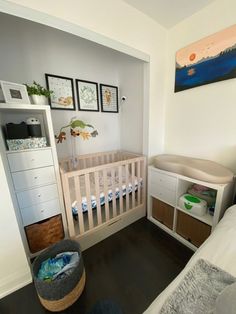 a baby's room with a crib, dresser and changing table in it