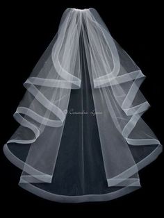 a white veil on top of a wedding dress in front of a black background with the word congratulations written below it