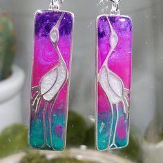 "One of a kind clay (blue, pink, purple and green blend) and resin (creates a glass like finish) standing crane earrings. Sterling silver charms are approximately 44x12mm with marbled clay which looks like stained glass. Hung on sterling silver ear wires.  Approximate length 2.75\".  Photos taken in studio light.  Free U.S. shipping on orders over $35. International shipping available. Same item as shown, contact me for free sizing adjustments. Shipped in a sealed and protected plastic bag. Free customer consultation offered to create a client profile I keep on hand with measurements and preferences for future orders. Thanks so much!  Smiles Jill" Silver Resin Drop Earrings, Nickel-free Silver Resin Earrings, Silver Resin Earrings As A Gift, Silver Resin Earrings For Gift, Artsy Purple Jewelry For Gifts, Hand Painted Multicolor Sterling Silver Earrings, Artistic Purple Earrings For Gift, Artistic Pink Resin Jewelry, Artistic Hand Painted Purple Jewelry