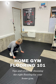 a woman kneeling down on the floor in front of a gym sign that reads home gym flooring 101