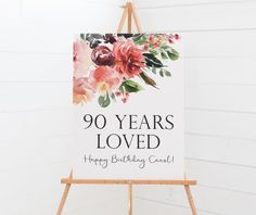 a sign that says 90 years loved happy birthday card on an easel against a white wall