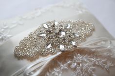 a white wedding garter with crystal brooches on it