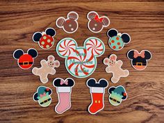 the mickey mouse christmas stickers are arranged in a circle on top of a wooden table