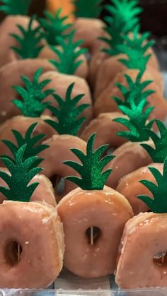 there are many donuts with green pineapples on them in the shape of apples