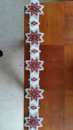 a close up of a decorative object on a wooden floor next to a person's feet