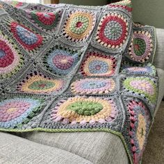 a crocheted blanket is sitting on a couch