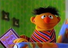 the muppet is holding a book in his hand