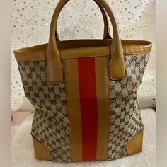 Gucci Gg Canvas Monogrammed Shopper Tote Bag Large. Tan Leather Trim, Orange/Tan Stripe Down Both Sides. Tan Leather Handles, Corners, And Bottom. All In Amazing Condition. The Only Call Out Is Rubbing On The Corners Which Is Not Major Rubbing. Look At All Pictures. Please Ask Questions, And Lmk If You Have An Offer For This Adorable Bag!! No Rips No Tares No Piping Issues Only Call Out Minor Rubbing On The Corners. The Bottom Is In Incredible Condition! Dc: 002.193.3444 13in X 15in. X 7.5in Pre-owned Brown Monogram Canvas Bag, Pre-owned Designer Brown Bags, Gucci Shoulder Bag With Leather Trim And Double Handle, Gucci Shoulder Bag With Double Handle And Leather Trim, Designer Monogram Canvas Shoulder Bag In Beige, Designer Pre-owned Shopping Bag, Pre-owned Brown Top Handle Shoulder Bag, Pre-owned Rectangular Gucci Bag, Pre-owned Gucci Leather Bag