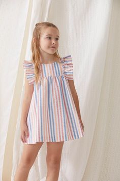 Brand: Tartaleta Reference: B4631.B463 Color: Multicolor Composition: 100% cotton Description: ﻿This dress is made in a striped, orange, coral and blue fabric. It has ruffles on the sleeves and fastens with buttons in the back. Intended Age: Toddler Girl, Girl Size Guide: ﻿This brand runs small. Please size up. Summer Outfits For Kids, Spoiled Girl, Kids Dress Clothes, Cotton Frocks For Kids, Kid Dress, Kids Summer Dresses, Fancy Short Dresses, Informal Dress, Coral And Blue