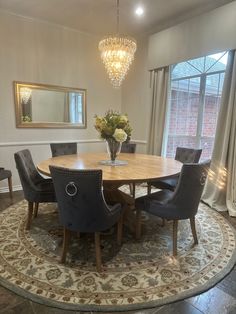 a dining room table with chairs around it and a chandelier hanging from the ceiling