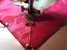 the sewing machine is working on the pink material that has been stitched into it