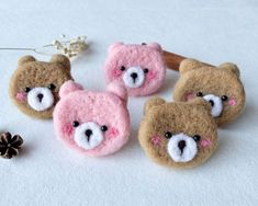 four small teddy bears made out of felt and wool, one with pink eyes and the other with white nose