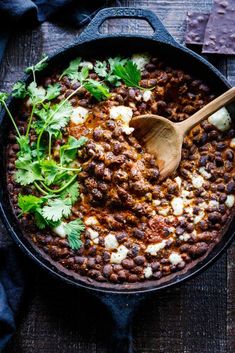 a skillet filled with beans, cheese and cilantro