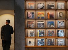 a man standing in front of a book shelf filled with books