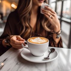 a woman sitting at a table with a cup of coffee