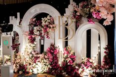 a floral backdrop with flowers and lights on the stage for a wedding ceremony or special event