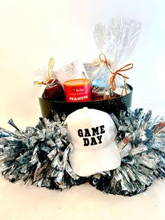 a white hat sitting on top of a pile of tinsel next to a basket