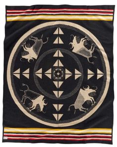 a black and white blanket with an animal design in the center, on a white background