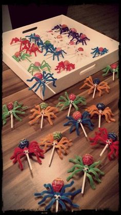 there are many spider lollipops in the box on the floor next to each other