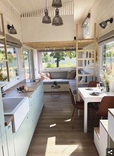 a kitchen and living room in a tiny home with wood flooring, white walls and ceiling