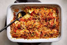 a casserole dish with zucchini, tomatoes and other vegetables in it