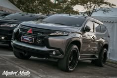 the front end of a silver truck parked next to other cars