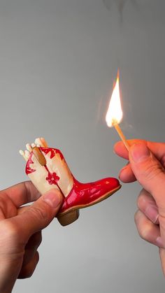 someone is lighting a matchstick with a shoe shaped like a boot on top of it